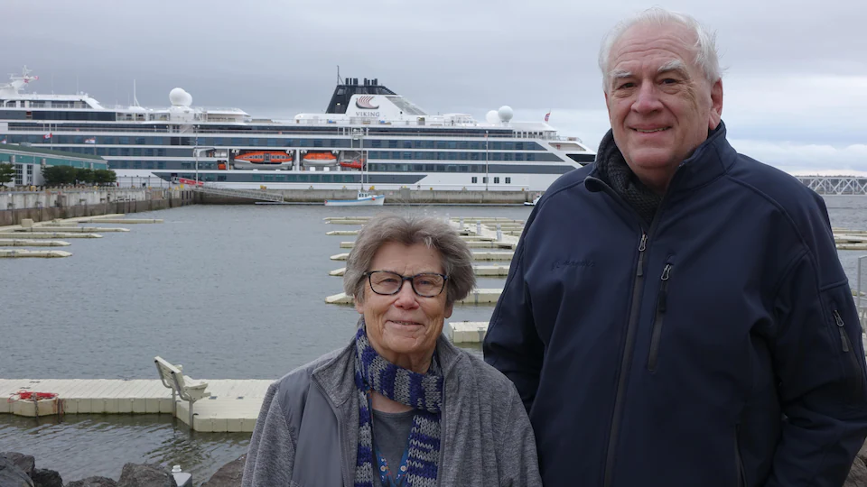 Katy et Gordon Hanneken posent pour la photo devant le bateau de croisière.