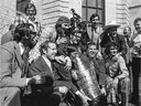 The Montreal Canadiens' Serge Savard and coach Scotty Bowman hold the Stanley Cup in 1973, surrounded by Jacques Laperrière (left), Ken Dryden (rear left), Guy Lafleur (second from left rear), trainer Eddy Palchak (next to Lafleur with arms around Savard and Bowman), Henri Richard (with cowboy hat) and goalie Michel Plasse (to the right of Bowman).