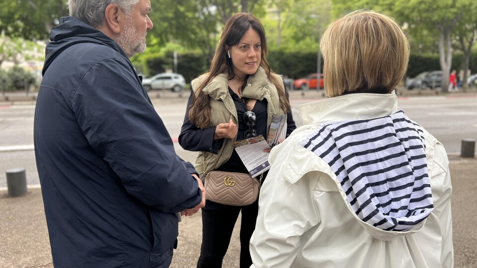 Eléonore Bez, une conseillère municipale du Rassemblement national, parle à une électrice lors d'un jour de marché, à Marseille.