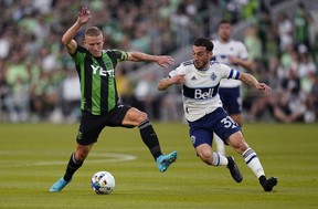 Austin FC midfielder Alex Ring, left, works the ball past Vancouver Whitecaps FC forward Russell Teibert (31) during the first half of an MLS soccer match, Saturday, April 23, 2022, in Austin, Texas.