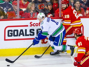 Apr 23, 2022;  Calgary, Alberta, CAN;  Vancouver Canucks center Matthew Highmore (15) controls the puck against the Calgary Flames during the first period at Scotiabank Saddledome.