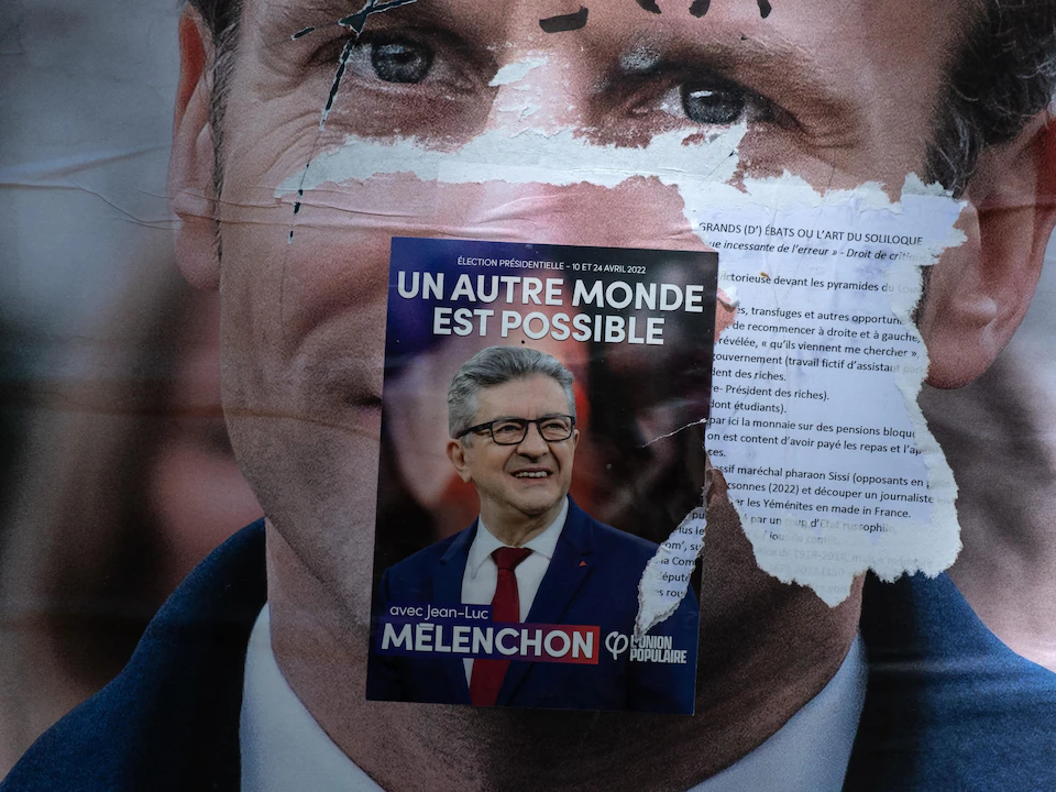 Une affiche de campagne de Jean-Luc Mélenchon est placardée par-dessus celle d'Emmanuel Macron, de La République en marche.