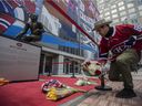 Patrick-Joseph Dufour lays flowers at the statue of Guy Lafleur outside the Bell Center in Montreal on Friday, April 22, 2022. 