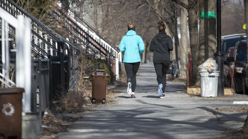 Deux femmes font de la course à pied sur la rue Christophe-Colomb à Montréal.