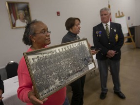 Bonita Seecharon, left, and Barbara Porter, from the Amherstburg Freedom Museum, present to President of the Royal Canadian Legion Branch 594, Tom Friesen, a photo of the No. 2 Construction Battalion, on Tuesday, April 26, 2022.