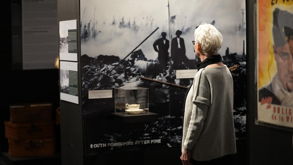 A woman looks at a photograph of a Great Fire. 