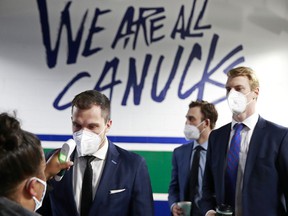 Bo Horvat, Brandon Sutter and Tyler Myers of the Vancouver Canucks get a temperature check before their NHL game against the Toronto Maple Leafs at Rogers Arena on April 18, 2021 in Vancouver.