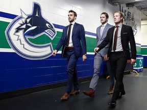 Brandon Sutter, Thatcher Demko and Brock Boeser of the Vancouver Canucks walk to the dressing room before their NHL game against the Detroit Red Wings at Rogers Arena October 15, 2019 in Vancouver.