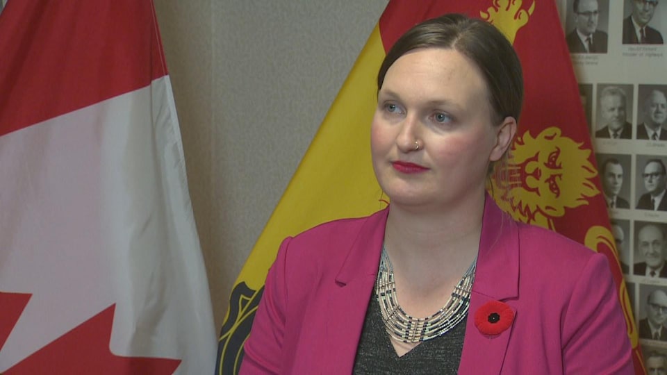 Megan Mitton during an interview in front of Canadian and New Brunswick flags. 