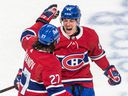 Montreal Canadiens defenseman Alexander Romanov congratulates fellow blue-liner Corey Schueneman on Schueneman's goal during third period at the Bell Center in Montreal on March 17, 2022. 