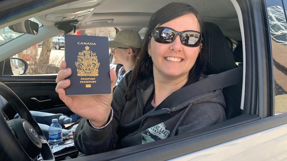 A woman holding a passport in one of her hands.