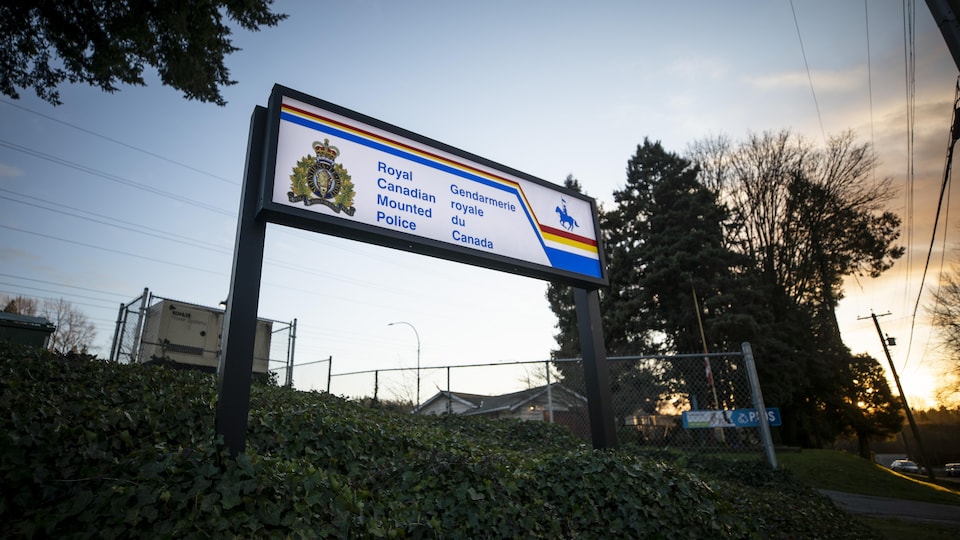 Bilingual RCMP sign photographed at sunset.