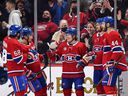 Canadiens teammates congratulate Cole Caufield, centre, for the first of his three goals Friday night at the Bell Centre.