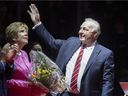 NHL hockey legend Guy Lafleur waves to Quebec Remparts fans as his wife Lise looks on during a ceremony to retire his No. 4 from the QMJHL on Oct. 28, 2021, at the Videotron Center in Quebec City. 