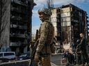 A Ukrainian serviceman stands near buildings destroyed by Russian shelling, as Russia's attack on Ukraine continues, in the town of Borodianka, Thursday, April 28, 2022.