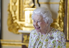 Queen Elizabeth II smiles as she arrives to view a display of artifacts from British craftwork company, Halcyon Days, to commemorate the company's 70th anniversary, in the White Drawing Room at Windsor Castle, March 23, 2022. (Steve Parsons/WPA Pool/Getty Images)