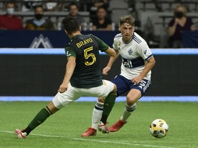 Portland Timbers defender Claudio Bravo defends against Vancouver Whitecaps midfielder Ryan Gauld at BC Place.