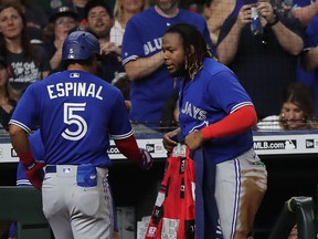Santiago Espinal #5 of the Toronto Blue Jays receives a jacket from Vladimir Guerrero Jr. #27 after hitting a home run in the fifth inning against the Houston Astros on Friday night.