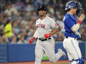 Boston Red Sox third baseman Rafael Devers (left) scores against the Toronto Blue Jays during the sixth inning at Rogers Center on Wednesday, April 27.