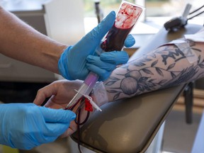 A man donates blood at the Canadian Blood Services donor center in London, Ont, Aug. 4, 2020.