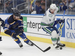 Vancouver Canucks' Conor Garland works the puck against the Blues' Colton Parayko during NHL action on March 28 in St. Louis.