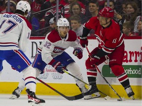 Carolina Hurricanes center Max Domi (13) holds onto the puck against Montreal Canadiens center Rem Pitlick (32) during the second period at PNC Arena on March 31, 2022.