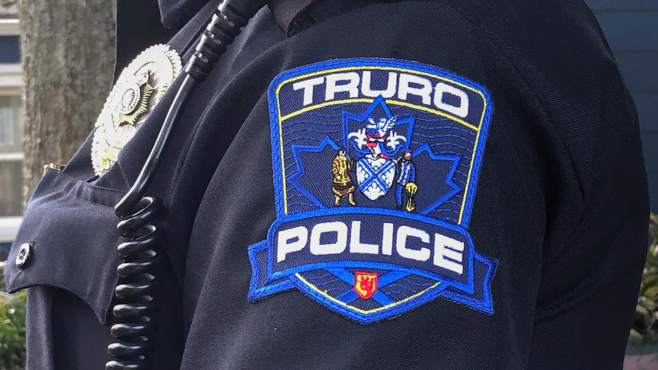 Écusson du service policier de Truro sur l'épaule d'un policier.