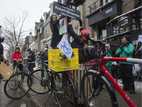 Karim Kammah attaches a sign at the corner of St-Denis and Roy Sts.  in Montreal on Saturday, March 12, 2022, in a ceremony to honor Robert 