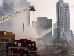 Edmonton Fire Rescue Services firefighters extinguish a fire in an abandoned building near 101 Street and 106 Avenue in Edmonton, on Sunday, April 10, 2022. A previous fire at the site destroyed the closed Mila Pub.