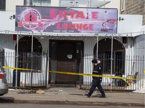 An Edmonton Police Service member investigates the scene of a shooting near 118 Avenue and 125 Street on Saturday, March 12, 2022.