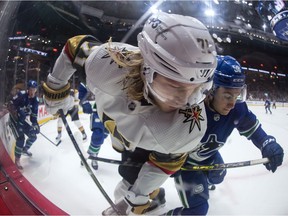 Vegas Golden Knights' William Karlsson (71) and Vancouver Canucks' William Lockwood (58) fries for the puck during the first period of an NHL hockey game in Vancouver, BC, Sunday, April 3, 2022.