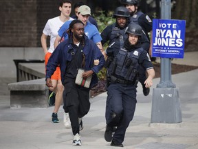 Metropolitan Police run as they escort people away from a shooting scene in the northwest part of Washington, DC, Friday, April 22, 2022.