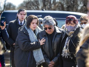 Luis Felipa, who lost his daughter, three grandchildren and son-in-law in a Brampton house fire early Monday, mourns beside five burial vaults containing their coffins before burial at Brampton Funeral Home and Cemetery in Brampton, Ont.  on Saturday April 2, 2022.