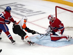 Flyers' Morgan Frost beats Canadiens goalie Carey Price as defenseman Alexander Romanov defends during the third period at the Bell Center Thursday night.
