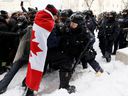 Police officers clash with protesters in Ottawa on February 19.