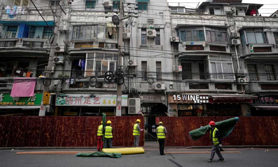 Les travailleurs ont mis en place des barrières avant la deuxième étape d'un verrouillage en deux étapes à Shanghai.