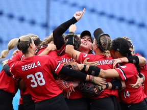 Canadian players celebrate their win, including pitcher Danielle Lawrie pointing to the sky, in the bronze-medal game at the Tokyo 2020 Olympics in Yokohama on July 27, 2021. Canada bear Mexico 3-2.