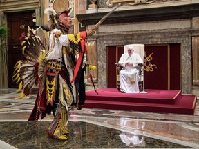 A member of Canada's Indigenous delegation chants and dances before Pope Francis during an audience at the Vatican.