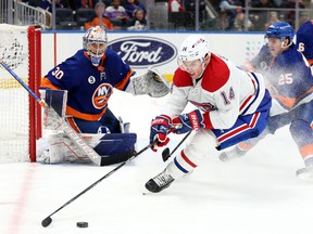 Montreal Canadiens center Nick Suzuki controls the puck as New York Islanders goaltender Ilya Sorokin looks on during the third period at UBS Arena in New York on Feb. 20, 2022.
