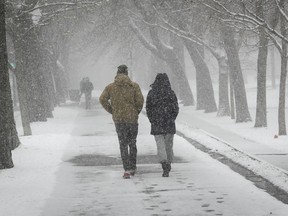 People make their way along the snowy paths of Lafontaine park during afternoon snowfall in Montreal on Wednesday April 21, 2021
