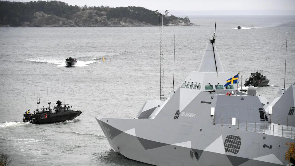 Un navire de guerre croise dans un fjord. 