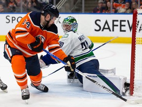 Goaltender Spencer Martin #30 of the Vancouver Canucks defends his net against Devin Shore #14 of the Edmonton Oilers during the second period at Rogers Place on April 29, 2022.