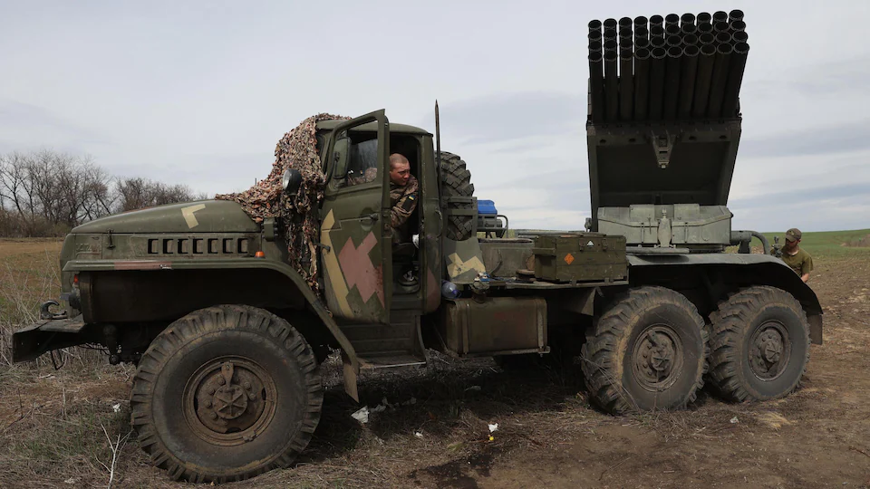Un militaire dans un véhicule qui transporte des roquettes. 