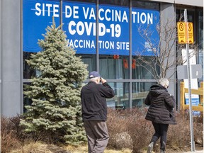 People walk past the COVID-19 vaccination clinic on Parc Ave.
