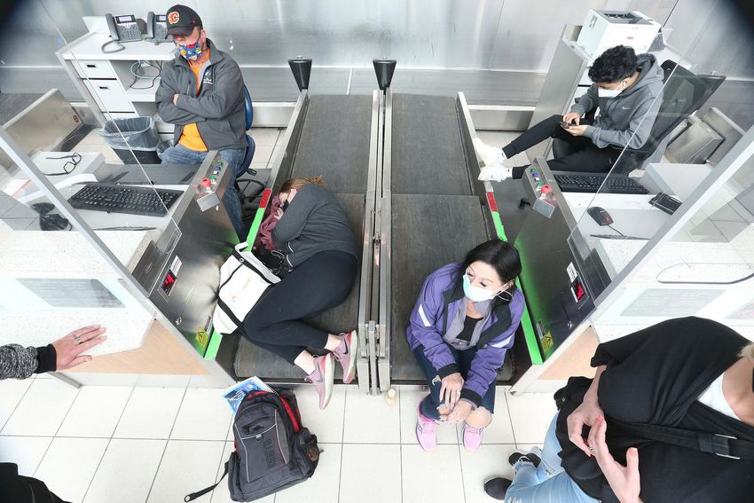 Passengers sleep on conveyer belts at Toronto Pearson Airport on Tuesday.