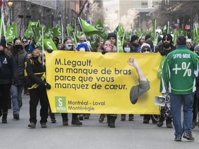 MONTREAL, QUE.: MARCH 30, 2022 -- Striking government workers walk along St-Antoine on Wednesday March 30, 2022 during their first day of strike.  More then 23000 members of the SFPQ staged a 24 hour strike in the province.  (Pierre Obendrauf / MONTREAL GAZETTE) ORG XMIT: 67610 - 6463