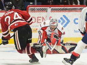 Windsor Spitfires' goalie Xavier Medina makes a save on Guelph Storm forward Matthew Papais while Windsor's Matthew Maggio chasing the play during Saturday's game.  Tony Saxon/GuelphToday.com