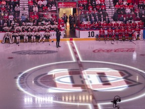 Players from the Boston Bruins and Montreal Canadiens watch a video in memory of Guy Lafleur at the Bell Center prior to game between the Montreal Canadiens and Boston Bruins in Montreal on April 24, 2022.