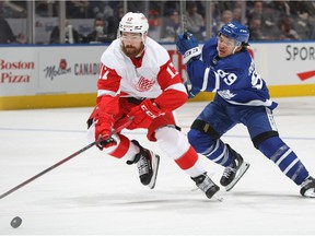 Filip Hronek of the Detroit Red Wings skates after the puck against Nicholas Robertson of the Toronto Maple Leafs during an NHL game at Scotiabank Arena on April 26, 2022 in Toronto, Ontario, Canada.