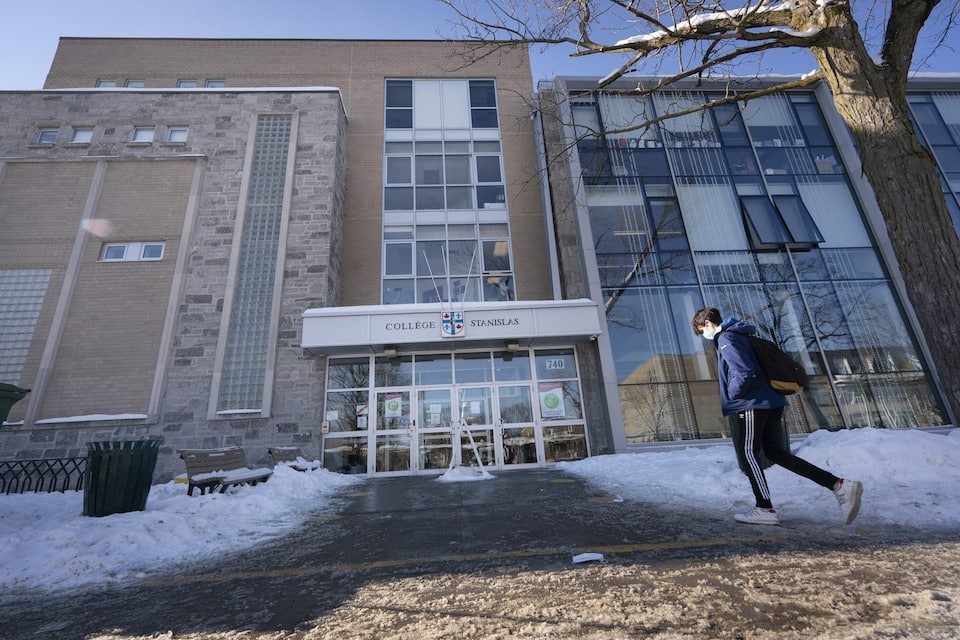 A student wearing a medical mask arrives at the College in winter.